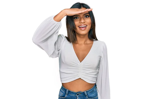 若いラテン系のトランスセクシャルトランスジェンダーの女性は カジュアルな服を着て 頭の上に手で遠くを見て非常に幸せと笑顔 検索の概念 — ストック写真