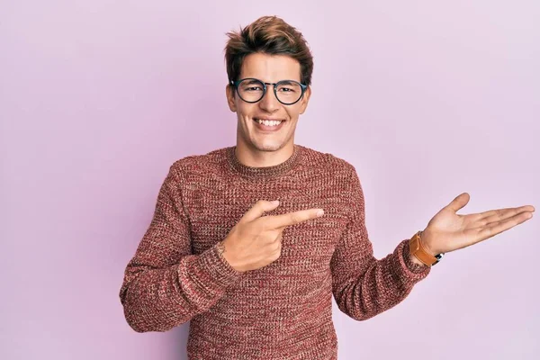 스웨터를 안경을 손가락으로 가리키는 카메라 앞에서 놀라며 미소를 코카서스 — 스톡 사진