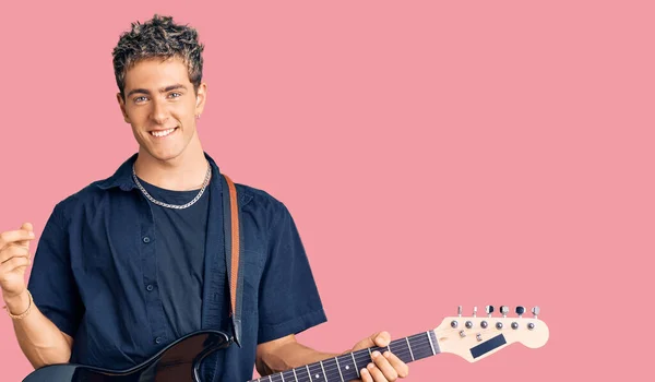 Jovem Homem Bonito Tocando Guitarra Elétrica Sorrindo Feliz Apontando Com — Fotografia de Stock