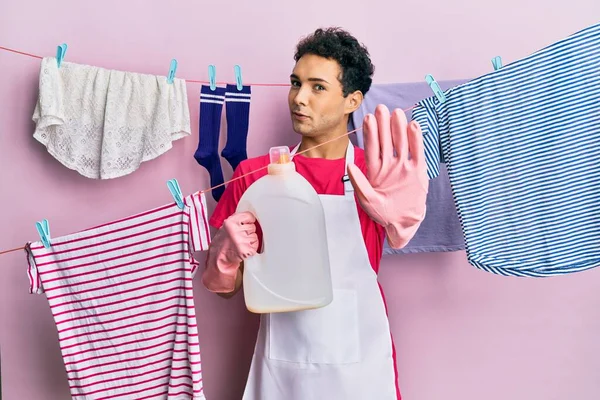 Hombre Hispano Guapo Lavando Ropa Sosteniendo Botella Detergente Con Mano — Foto de Stock