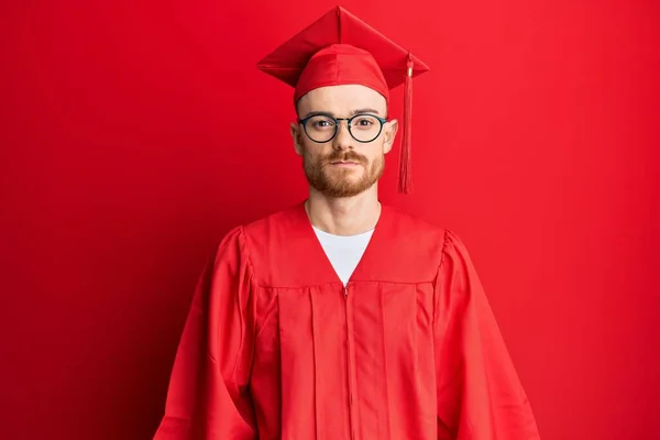 Young Redhead Man Wearing Red Graduation Cap Ceremony Robe Relaxed — Stock Photo, Image