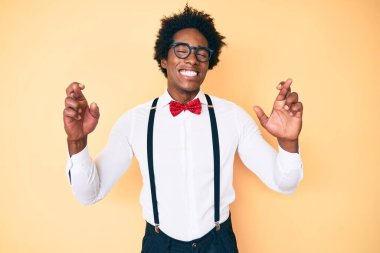 Afro saçlı yakışıklı Afro-Amerikan bir adam. Zarif görünüşlü. Umut ve gözler kapalı bir şekilde gülümseyerek el sallıyor. Şans ve batıl inançlar. 