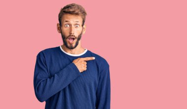 Sakallı, sıradan bir süveter giyen yakışıklı sarışın bir adam parmaklarını yana doğru göstererek şaşırdı, ağzı açık hayret içinde kaldı.. 