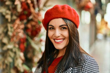 Genç İspanyol kadın gülümseyerek şehirde mutlu mesut dikiliyor..