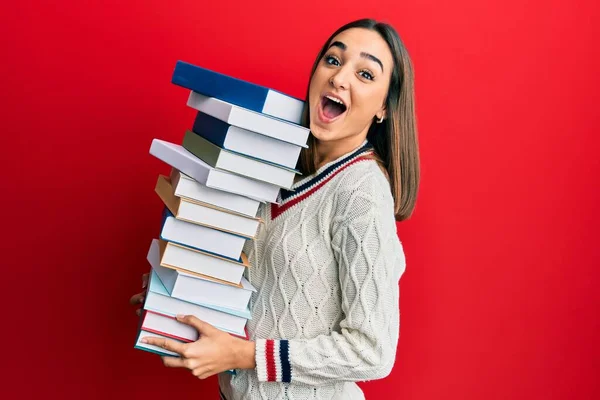 Young Brunette Student Girl Holding Pile Books Afraid Shocked Surprise — Stock Photo, Image