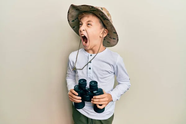 Pequeño Niño Caucásico Con Sombrero Explorador Sosteniendo Prismáticos Enojado Loco —  Fotos de Stock