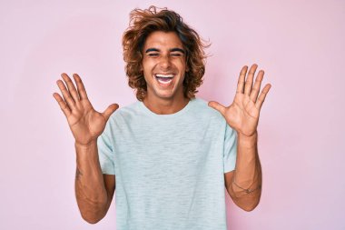 Gündelik kıyafetler giyen genç İspanyol adam başarı için deli ve çılgınlığı kutluyor kollarını kaldırmış ve gözlerini kapatmış heyecanla bağırıyor. Kazanan konsept 