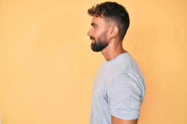 Latin kökenli genç adam rahat bir görünüm takınıyor, rahat bir görünüm takınıyor, kendine güvenen bir gülümsemeyle.. 