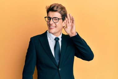 İş elbisesi ve kravat takmış yakışıklı beyaz bir adam. Kulağından kulağa gülümsüyor. Dedikoduları ve dedikoduları dinliyor. Sağırlık kavramı. 