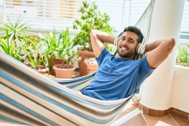 Genç İspanyol adam terasta uzanmış müzik dinlerken rahatladı..