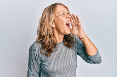 Orta yaşlı sarışın kadın gündelik kıyafetler giyip el ele tutuşarak bağırıyor ve bağırıyordu. iletişim konsepti. 