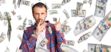 Gündelik giysiler giymiş genç yakışıklı adam sessiz olmak istiyor. Parmakları dudaklarında ve elleri yandan işaret ediyor. sessizlik ve gizli konsept.