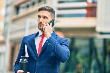 Kafkasyalı genç iş adamı ciddi bir ifadeyle şehirdeki akıllı telefondan konuşuyor..