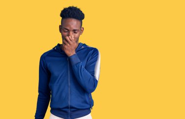 Genç Afro-Amerikan erkek spor giysisi giymiş pis ve iğrenç bir koku alıyor, dayanılmaz bir koku, nefesini tutuyor parmakları burnunda. Kötü kokuyor. 