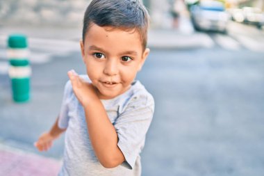 Sevimli İspanyol çocuk gülümseyerek şehirde mutlu bir şekilde oynuyor..