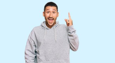 Sıradan tişörtler giyen yakışıklı bir adam başarılı bir fikri işaret ediyor. Heyecanlı ve mutlu. Bir numara.. 