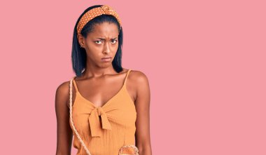 Genç Afrikalı Amerikalı kadın yaz kıyafeti giyiyor şüpheci ve gergin, sorun yüzünden üzgün. negatif kişi. 