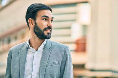 Genç İspanyol işadamı gülümseyerek şehirde mutlu mesut duruyor..