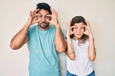 Beautiful young couple of boyfriend and girlfriend together trying to open eyes with fingers, sleepy and tired for morning fatigue 