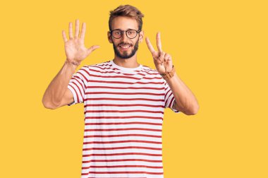 Yakışıklı, sakallı, sıradan kıyafetler giyen, gözlüklü, yedi numaralı parmaklarıyla işaret eden, kendinden emin ve mutlu bir adam.. 