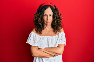 Orta yaşlı İspanyol kadın gündelik kıyafetler giyiyor. Kuşkucu ve gergin. Yüzünde çapraz kollu tasvip etmeyen bir ifade. negatif kişi. 