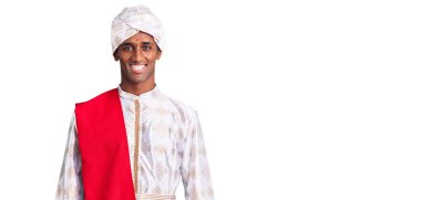 Geleneksel Sherwani sari giysileri giyen yakışıklı Afrikalı bir adam. Yüzünde mutlu ve havalı bir gülümseme var. şanslı kişi. 