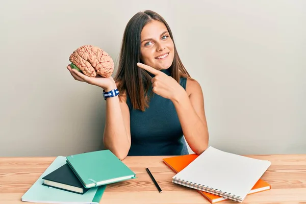 Mulher Branca Jovem Segurando Cérebro Enquanto Estudava Para Escola Sorrindo — Fotografia de Stock