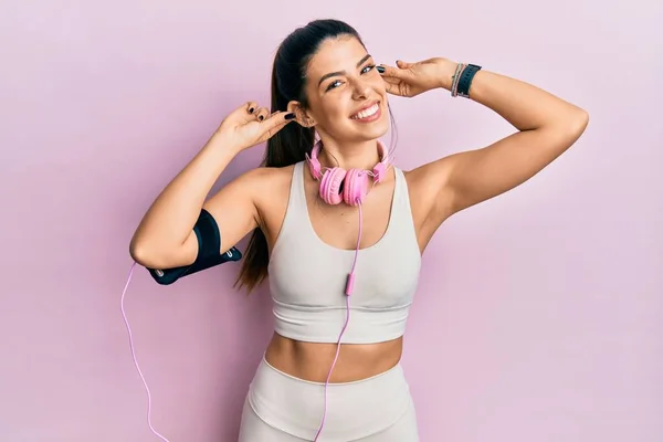 Mujer Hispana Joven Vistiendo Ropa Gimnasio Usando Auriculares Sonriendo Tirando —  Fotos de Stock