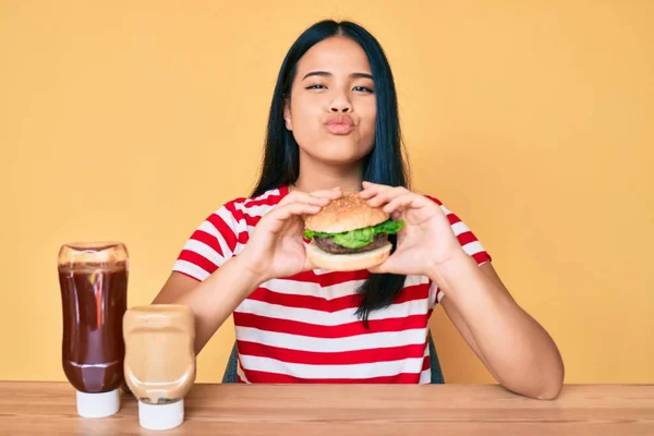 Fiatal Ázsiai Lány Eszik Egy Ízletes Klasszikus Burger Néz Kamera — Stock Fotó