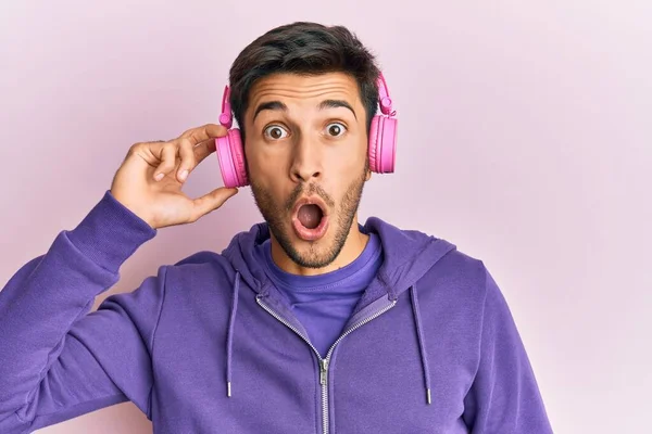 Joven Hombre Guapo Escuchando Música Usando Auriculares Asustados Sorprendidos Con —  Fotos de Stock