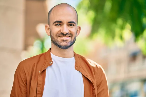Young hispanic bald man smiling happy standing at the city.
