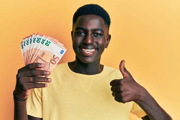 Νεαρός Αφροαμερικάνος Που Κρατά Χαρτονομίσματα Των Ευρώ Χαμογελώντας Χαρούμενος Και — Φωτογραφία Αρχείου