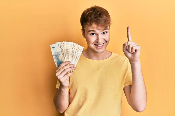 Joven Hombre Caucásico Sosteniendo Billetes 100 Coronas Danesas Sonriendo Con —  Fotos de Stock