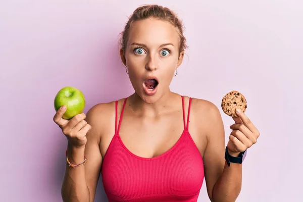 Beautiful Caucasian Woman Holding Green Apple Cookie Afraid Shocked Surprise — 图库照片