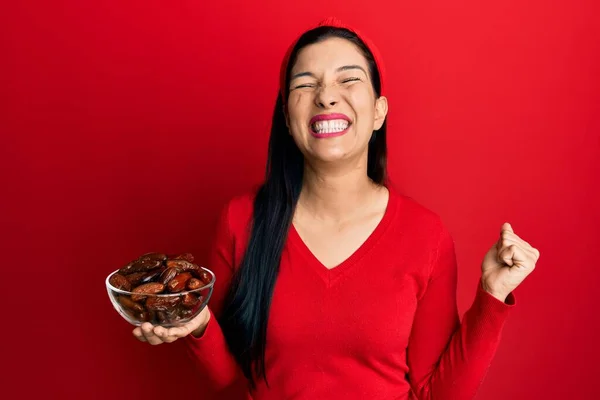 Mujer Latina Joven Sosteniendo Tazón Con Fechas Gritando Orgulloso Celebrando — Foto de Stock