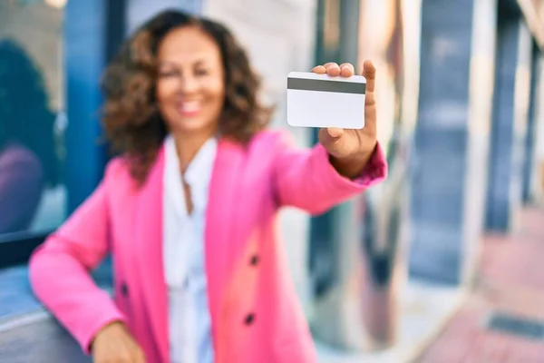 中年时 他惊慌失措的女商人笑着 高高兴兴地拿着信用卡站在城里 — 图库照片