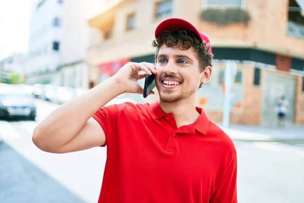 若い白人の配達人は 市内のスマートフォンで話して会話をして幸せな笑顔 — ストック写真