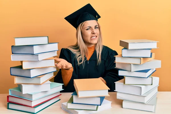 Junge Kaukasische Frau Abschlusszeremoniengewand Sitzt Auf Dem Tisch Und Lächelt — Stockfoto