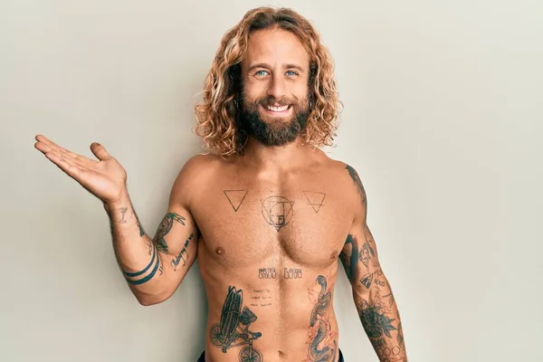 Pohledný Muž Vousy Dlouhými Vlasy Bez Trička Ukazující Tetování Veselým — Stock fotografie