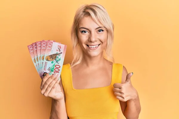 Mladá Blondýnka Drží 100 Dolarů Novozélandských Bankovek Úsměvem Šťastný Pozitivní — Stock fotografie