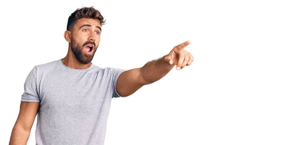 Young Hispanic Man Wearing Casual Clothes Pointing Finger Surprised Ahead — Stock Photo, Image