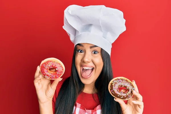Jovem Bela Menina Hispânica Usando Chapéu Chef Segurando Donut Caseiro — Fotografia de Stock
