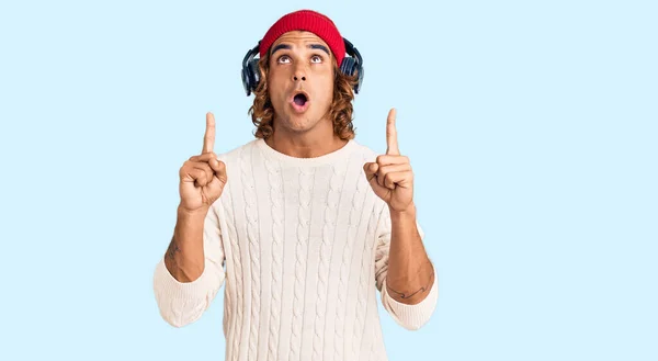 Young Hispanic Man Listening Music Using Headphones Amazed Surprised Looking — Stock Photo, Image