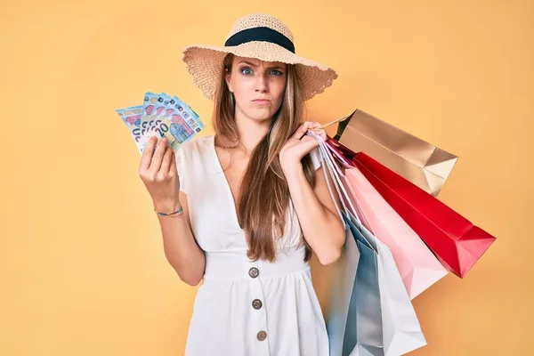 Ung Blond Flicka Håller Shoppingväskor Och Eurosedlar Skeptiska Och Nervösa — Stockfoto