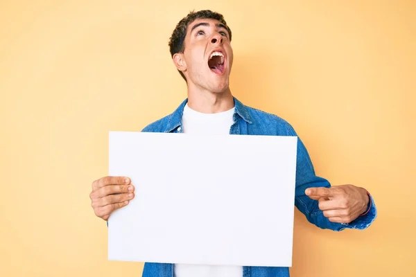 Joven Hombre Guapo Sosteniendo Banner Vacío Blanco Enojado Loco Gritando — Foto de Stock