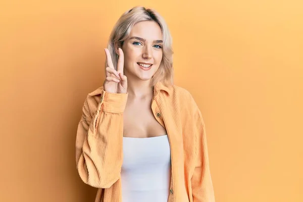 Młoda Blondynka Luźnych Ubraniach Pokazując Wskazując Palcami Numer Dwa Uśmiechając — Zdjęcie stockowe