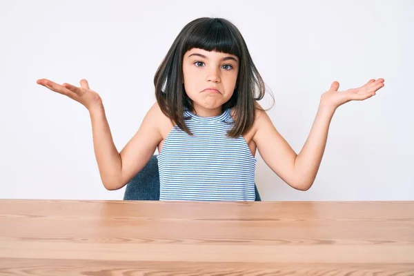 Jong Meisje Met Bang Dragen Casual Kleren Zitten Tafel Onwetend — Stockfoto