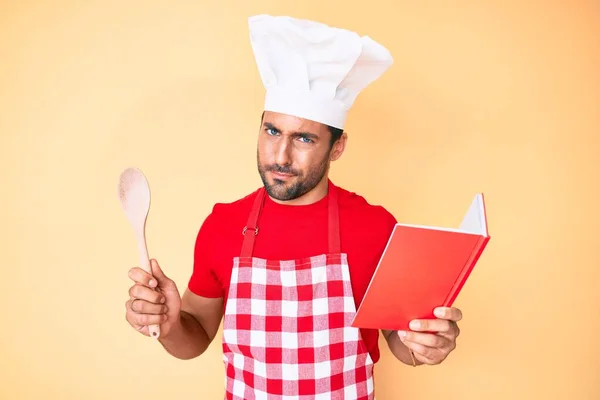 Jovem Hispânico Vestindo Avental Padeiro Profissional Ler Livro Receitas Culinária — Fotografia de Stock