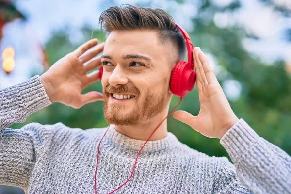 Νεαρός Καυκάσιος Άνδρας Χαμογελά Χαρούμενος Ακούγοντας Μουσική Χρησιμοποιώντας Ακουστικά Στο — Φωτογραφία Αρχείου