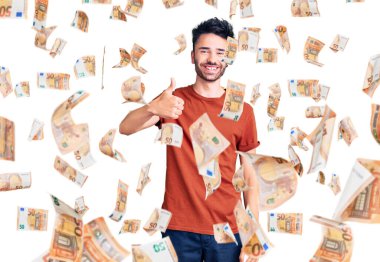 Neşeli ve pozitif gülümseyen İspanyol asıllı genç adam, mükemmel ve onay işareti yapıyor.